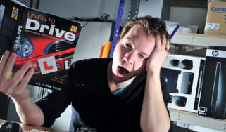 Tired man studying from driving theory test book